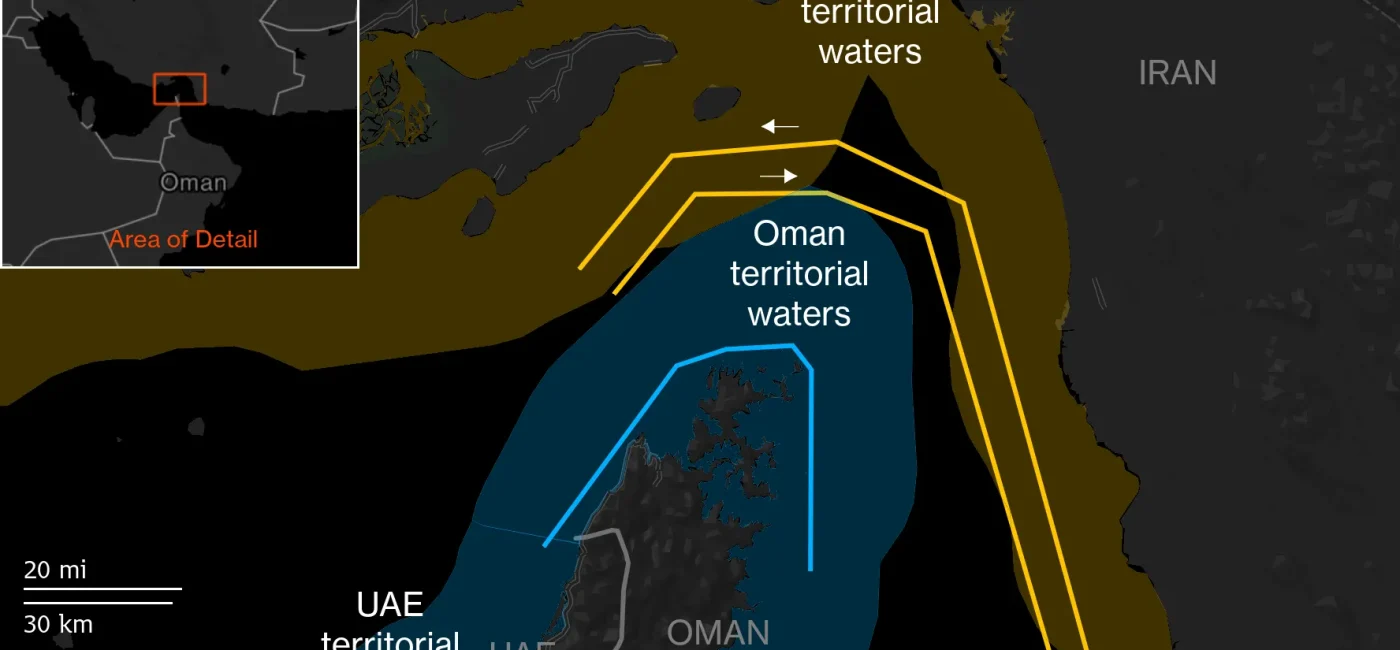 Map showing proposed Hormuz transit corridors: Iran-designated in yellow and JMIC-designated in blue, around Oman, UAE, and Iran waters with an inset highlighting a detail area.