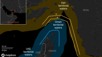 Map showing proposed Hormuz transit corridors: Iran-designated in yellow and JMIC-designated in blue, around Oman, UAE, and Iran waters with an inset highlighting a detail area.