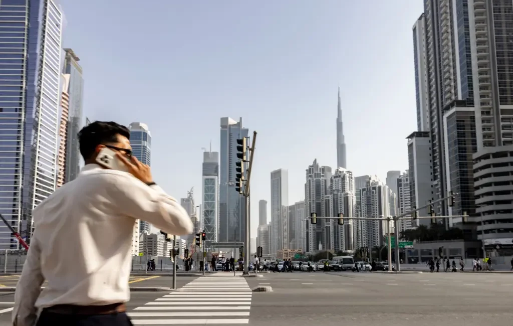 Pedestrian on phone with Dubai skyline and Burj Khalifa in background