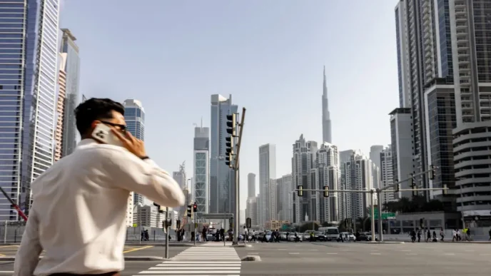 Pedestrian on phone with Dubai skyline and Burj Khalifa in background