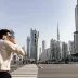 Pedestrian on phone with Dubai skyline and Burj Khalifa in background