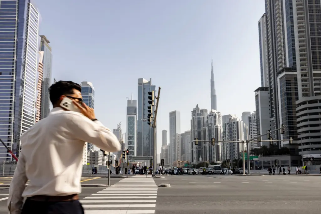 Pedestrian on phone with Dubai skyline and Burj Khalifa in background