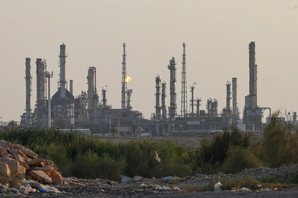 Saudi oil refinery with flare stacks at dusk